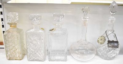 A group of five cut glass decanters, with two silver plated labels, one inscribed 'Gin', the