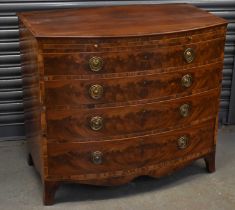 An early 19th century mahogany and crossbanded bowfront chest with brushing slide above four long