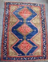 A large Persian red and blue ground rug with geometric design, 152 x 275cm.