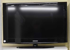 A Samsung 31'' television with three remote controls.