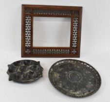 An Islamic slate pierced dish, an Islamic slate and white metal dish and a wooden picture frame (