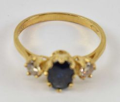 An 18ct yellow gold ring set with central blue stone and two white stones either side, size N,