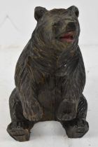 A Black Forest carved model of a seated bear, height 21.5cm.