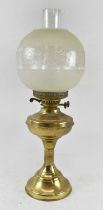 A late 19th century brass oil lamp with frosted glass shade, height to top of chimney 55cm.