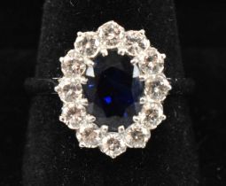 An 18ct white gold and platinum ring set with central sapphire surrounded by twelve small