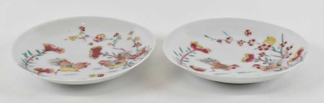 A pair of Chinese Yongzheng period Famille Rose saucer dishes, each painted with two chickens,