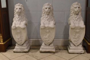 A group of three white painted stone lions, with shield fronts, height of each lion approx 84cm.