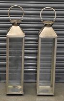 A pair of large modern stainless steel lanterns, with handles to the top, height 90cm.