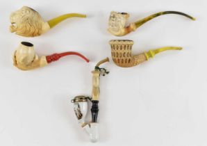 A group of Meerschaum pipes, including one modelled as a dragon, another modelled as a claw