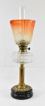 A Victorian oil lamp on brass base, with orange glass shade, height to top of chimney approx 64cm.