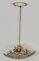 A yellow metal diamond set crescent brooch with revolving central flowerhead, length 5cm, approx 7.