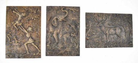 † A group of three heavy bronzed metal plaques, one depicting a stag, another depicting three