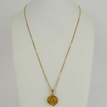 An 18ct gold Egyptian rose pendant, diameter 1.7cm, on an 18ct gold dainty box link chain, length