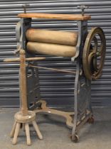 OWEN & OWEN LTD OF LIVERPOOL; a cast iron mangle and stool, width of mangle 83cm, height 126cm.