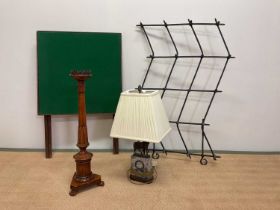 A contemporary table lamp, wooden candle stick, baize covered card table, and a cast iron wall