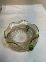 An Art Nouveau slightly iridescent glass bowl with shaped green tinted rim and three green glass