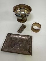 a silver money clip, napkin ring, footed bowl and white metal dish embossed with an elephant