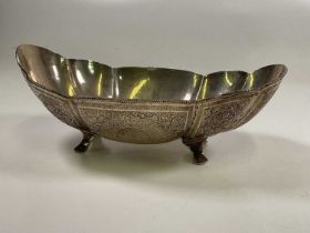 An Eastern white metal lobed bowl with engraved detail and raised on four swept supports, width