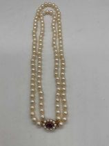 A hand tied double strand of pearls with 9ct yellow gold amethyst and pearl clasp, length 40cm,