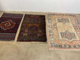 A vintage detailed Persian Baluchi rug with another Persian small rug and a peach cream and blue