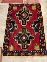 A vintage Afghan woollen rug, with two others, 143cm x 93cm