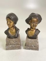 AFTER GIOVANNI DE MARTINO; a pair of bronze figural busts raised on stepped marble bases, height