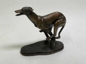 A figure of a bronze effect racing greyhound, height 19cm