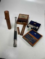A leather cased two draw telescope, a printer's stamp in vintage wooden box, a boxed ultra lens,