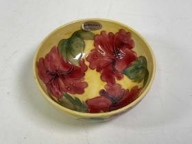 MOORCROFT; a yellow ground pink 'Hibiscus' decorated bowl, with painted and impressed marks, also