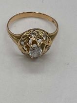 A 14ct yellow gold ring with central white stone surrounded by 6 smaller stone (1 missing), size P