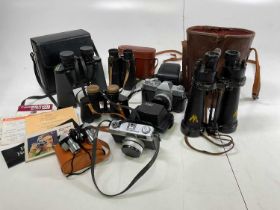 A collection of binoculars and cameras including cased military binoculars, Carl Zeiss, Green Cat