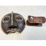 An early 20th century python skin adorned and cowrie shell applied African tribal mask, width
