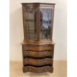 An Edwardian mahogany bookcase on chest, the glazed two door upper section above a serpentine base