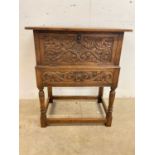 An early 20th century carved wooden box on stand, with drop-down door and drawer beneath, height