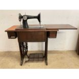 A Singer treadle sewing machine set into a folding table.