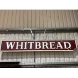 A large advertising sign 'Whitbread' on plyboard backing, loss to lower right cornerDimensions: H: