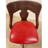 An early 20th century revolving office chair with leatherette padded seat.