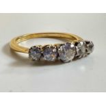 A yellow metal five stone graduated diamond ring, the central stone approx. 0.40cts, size N, approx.