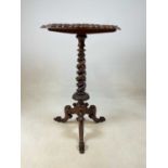 A Victorian walnut barley twist occasional table with a circular top and curved tripod base 73cm h x