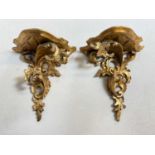 A pair of ornate gilded wall brackets