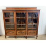 An early 20th century triple door glazed bookcase with adjustable shelves, with working key,