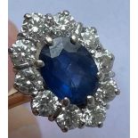 A good yellow and white metal diamond and sapphire oval cluster ring with central oval sapphire