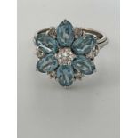A white metal diamond and aquamarine flowerhead dress ring, unmarked, size N 1/2, approx. 5g.