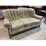 An Art Deco cloud back sofa with veneered show frame and raised on front castors.