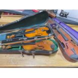 Three cased violins, for restoration.