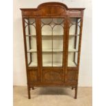 An early 20th century walnut veneered single door glazed display cabinet, with lined interior,