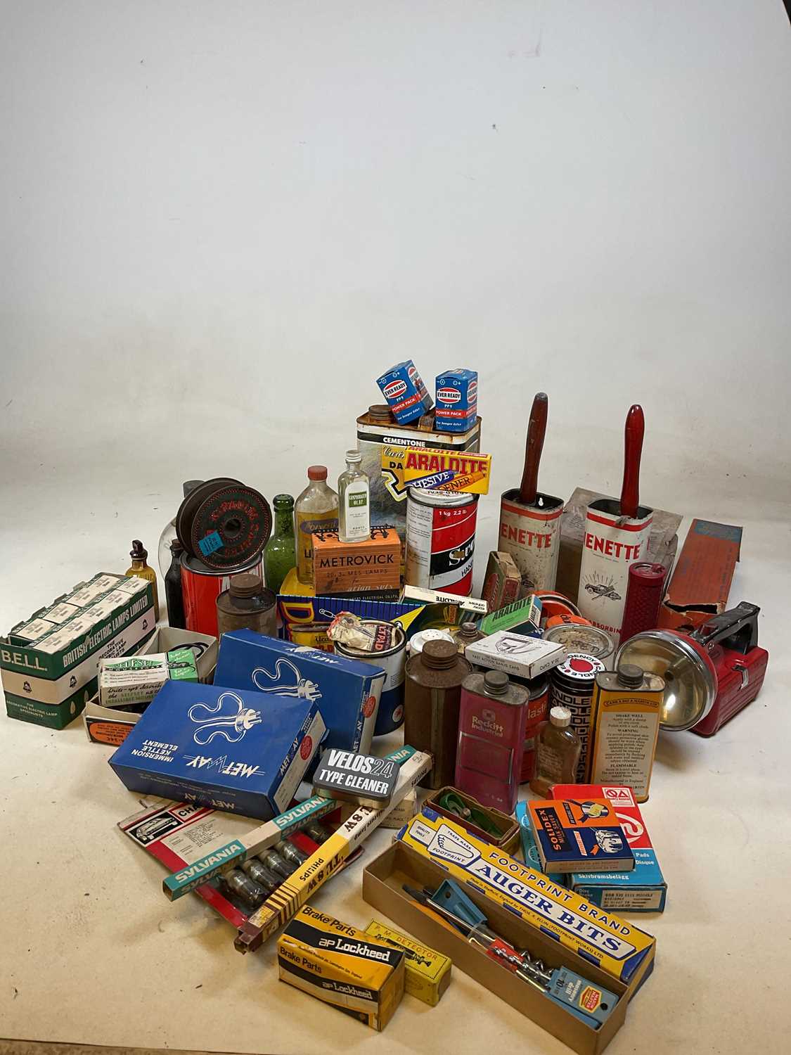 A collection of vintage tins and workshop finds including torches, car components, light bulbs,