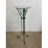 A wrought iron stand with conical glass jardiniere or light holder.