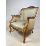 An early 20th century gilt framed French padded elbow chair raised on cabriole front legs.