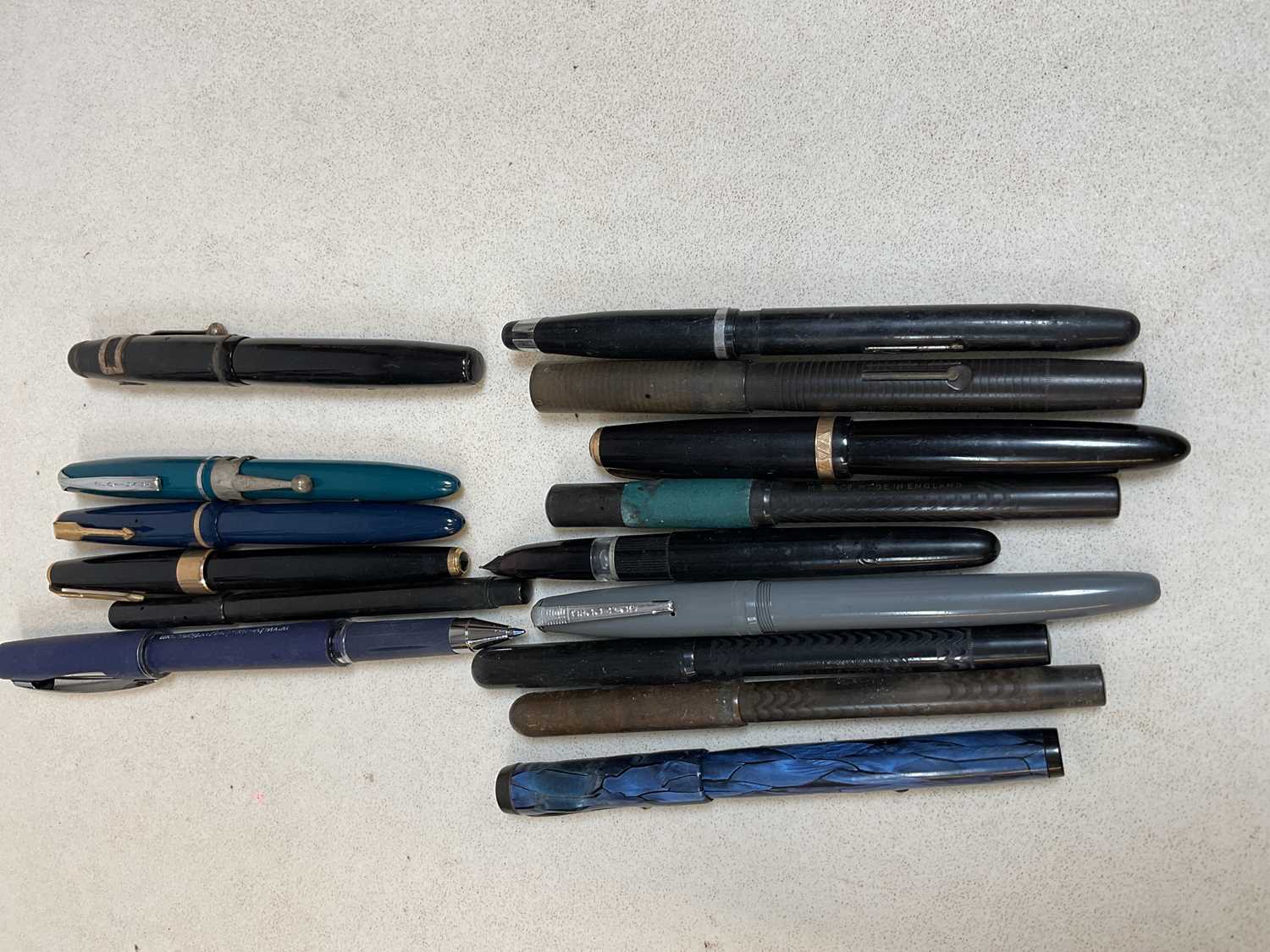 A group of vintage pens, including a Parker 17, a blue bodied Parker Victory, etc.